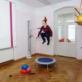 Turnraum mit Trampolin. Frau Baumann während eines Sprunges